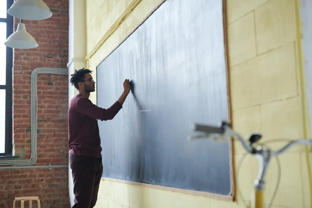 young adult writing on blackboard