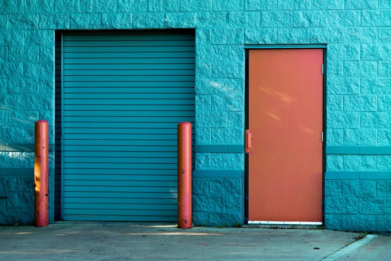 a garage door and a door in a wall made of stone